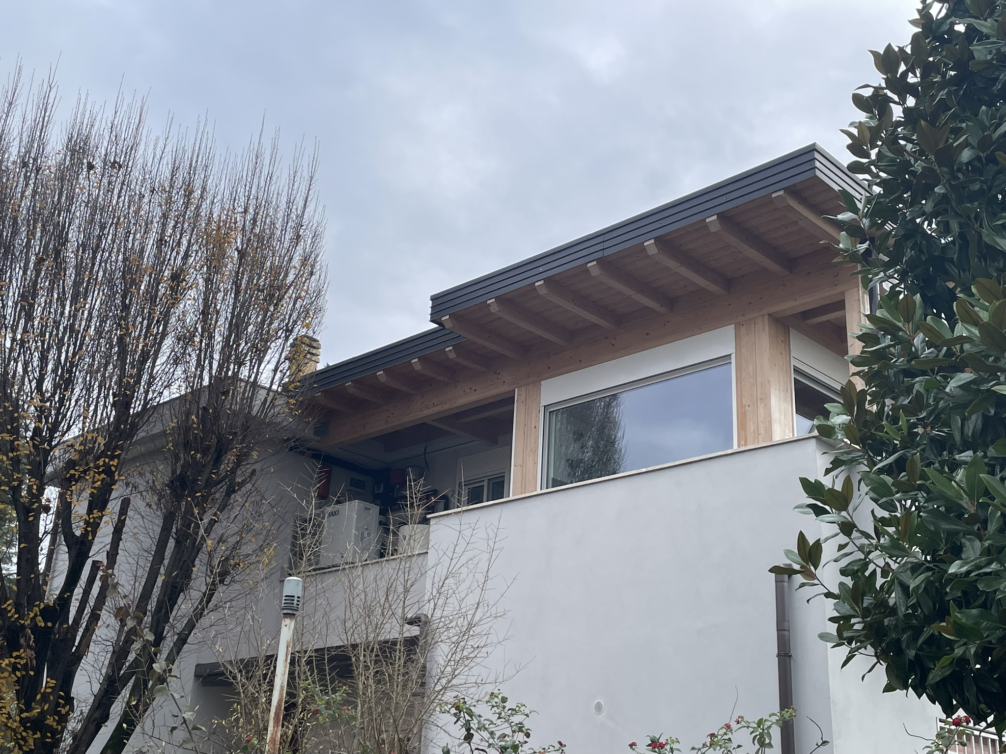 Vista esterna di una sopraelevazione in legno moderna completata sopra un edificio esistente in muratura