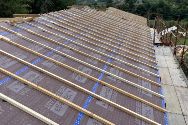 Fase di fissaggio dei listelli di ventilazione sul pacchetto isolante di un tetto in legno