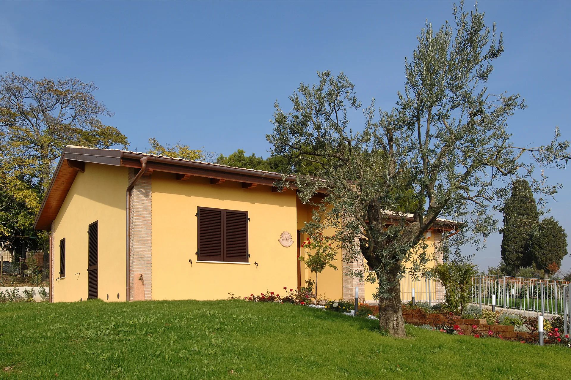 Prospettiva con dettaglio parete con persiana ed ulivo di una casa in legno prefabbricata a Rieti