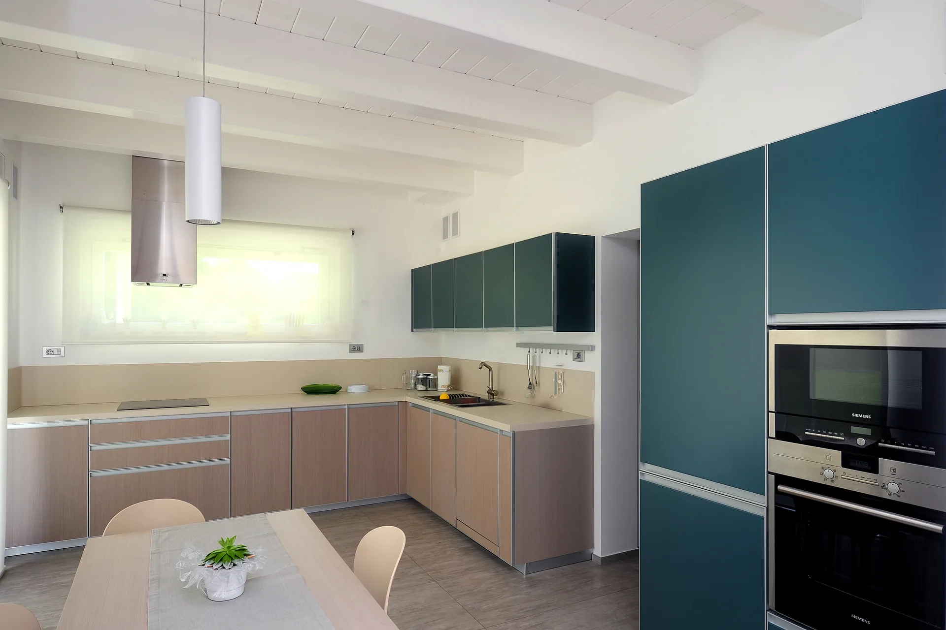 Cucina moderna ad angolo con isola all'interno di una luminosa casa passiva