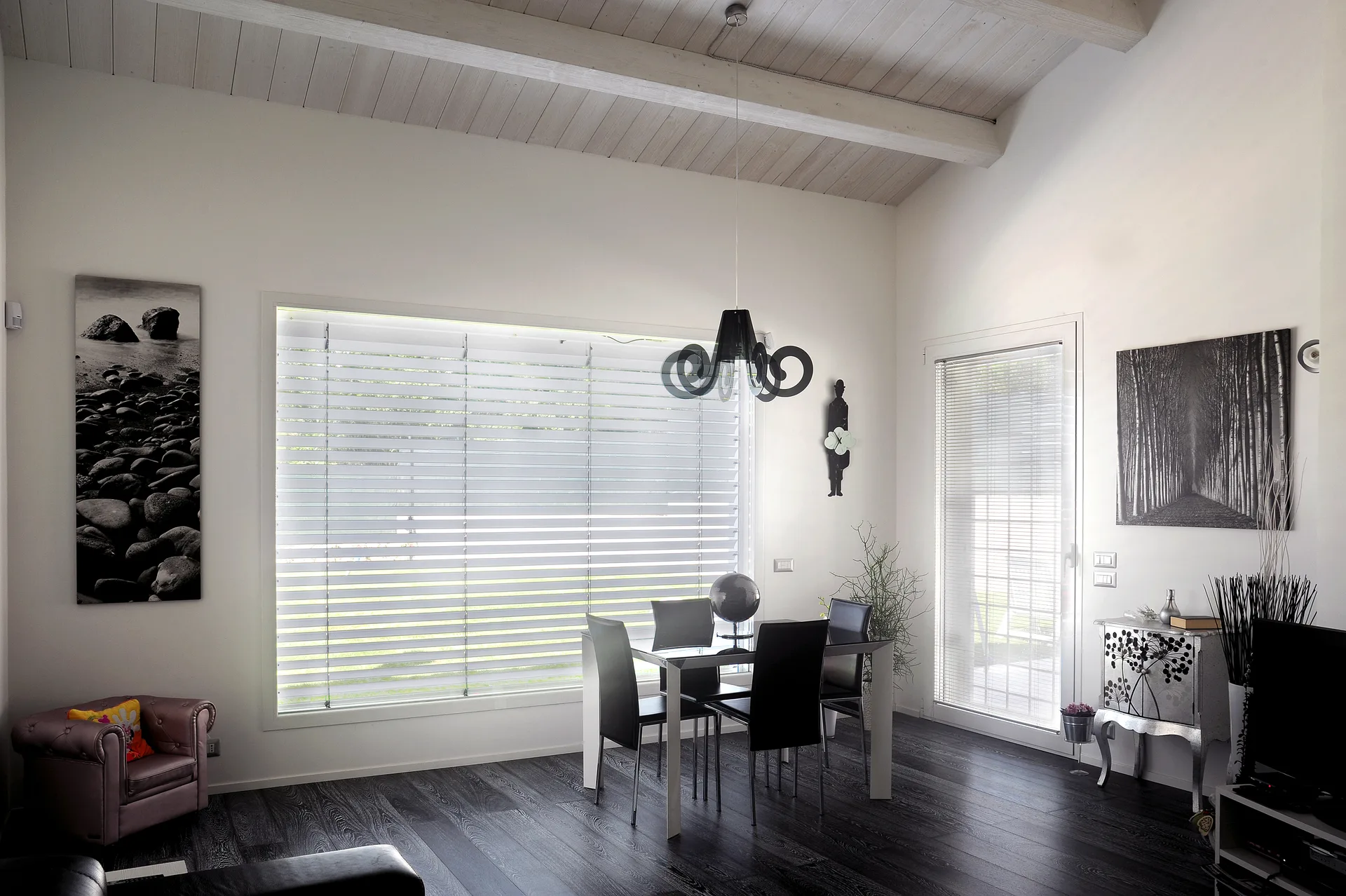 Interni luminosi di una villa prefabbricata a Latina con travi a vista bianche nel salone